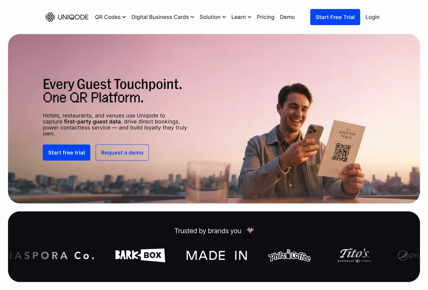 The new hospitality landing page: the same headline in a lighter pixel font, a lifestyle photo of a man scanning a restaurant QR code at sunset, and a black trusted-by-brands bar.